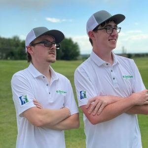 2 boys waiting their turn at golf